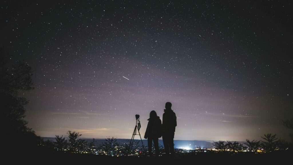 astronomy photography tips: two people with camera under a starry sky