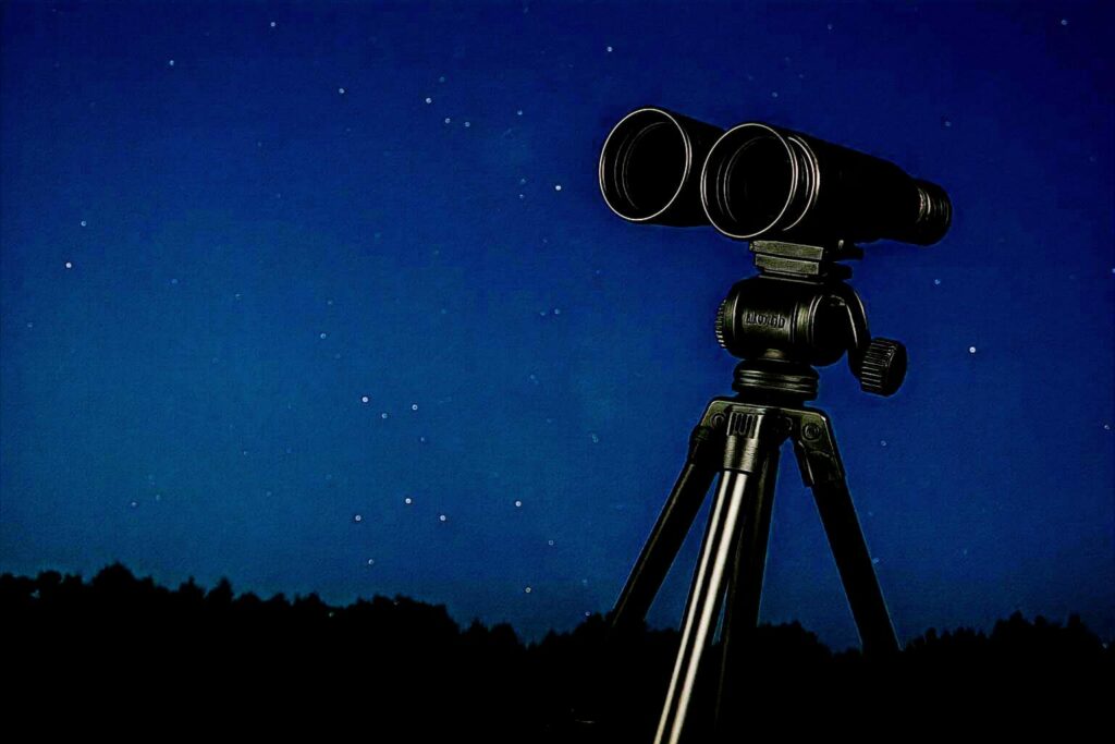 Tripod supporting astronomy binoculars for steady night sky viewing