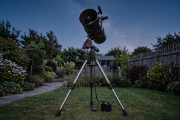 Reflector telescope set-up in a garden at night