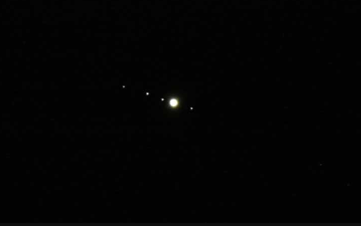 Jupiter and four moons seen through binoculars