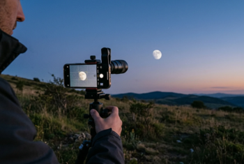 Smartphone mounted on a tripod photographing the Moon